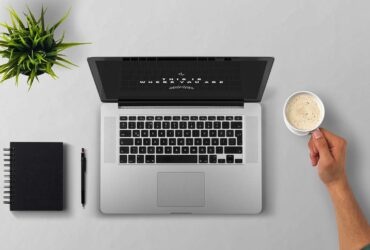 Minimalist workspace with laptop, notebook, and coffee cup representing a clutter-free digital life.