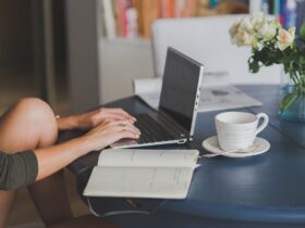 Minimalist home office setup with laptop, notebook, and plant for calm and focused work.