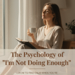 Calm minimalist workspace with a woman journaling near a window, symbolizing mindful reflection and balance.